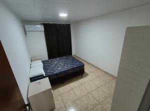a small bedroom with a bed and a black curtain at Departamentos Don Julio in Guaraní