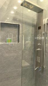 a shower with a glass door in a bathroom at Al Joud Chalet Private Jacuzzi & BBQ Ajloun in Ajloun +17 photos