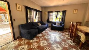 a living room with two chairs and a couch at Tuncosurfhouse in El Sunzal