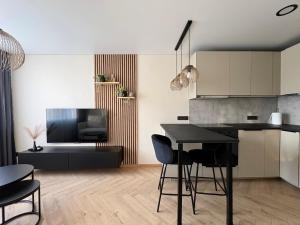 a kitchen and living room with a table and chairs at Work & Stay Apartment Klaipėda in Klaipėda