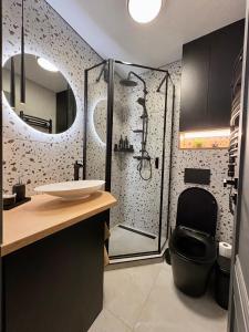 a bathroom with a shower with a toilet and a sink at Work & Stay Apartment Klaipėda in Klaipėda