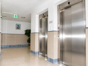a hallway with two elevators in a building at Hotel Donaustadt Kagran - at Metro U1 in Vienna