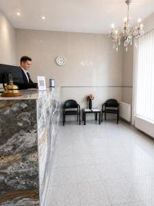 a man sitting at a counter in a waiting room at Hotel Donaustadt Kagran - at Metro U1 in Vienna