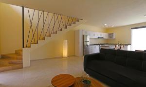a living room with a black couch and a staircase at Departamentos VESA in Ajijic