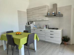 a kitchen with a yellow table with chairs and a sink at Villa Carbonilla in Torre del Greco