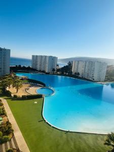 a large swimming pool in a city with tall buildings at Papudo laguna in Papudo