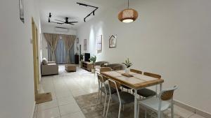 a dining room and living room with a table and chairs at Zahran Homestay in Papar