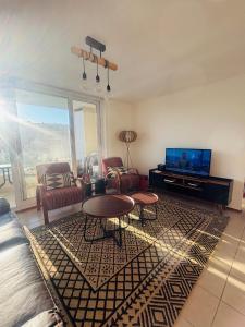 a living room with a couch and a table and a tv at Papudo laguna in Papudo