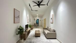 a living room with a couch and a ceiling fan at Zahran Homestay in Papar