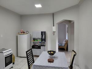 a kitchen with a table with chairs and a refrigerator at Nosso Lar casa inteira, completa e independente in Barra do Garças
