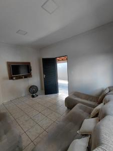 a living room with a couch and a flat screen tv at Nosso Lar casa inteira, completa e independente in Barra do Garças