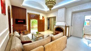 a living room with a couch and a fireplace at Villa familiale avec piscine privée sans vis à vis in Oulad Raho