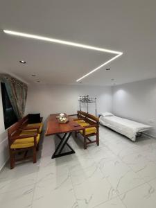 a living room with a table and chairs and a bed at Happy Stayy in Patza-Kuqani