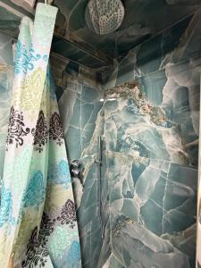 a shower in a bathroom with blue and white tiles at Happy Stayy in Patza-Kuqani +38 photos