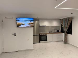 a kitchen with a flat screen tv on the wall at Happy Stayy in Patza-Kuqani