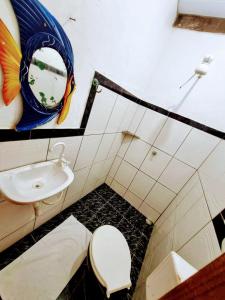 a bathroom with a toilet and a sink and a mirror at MistiHouse Surf & Amor con vista al mar a 50 mts de la playa in Itacaré