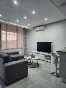 a living room with a couch and a flat screen tv at Casa Strela Negra in Tarrafal