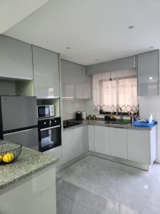 a large kitchen with white cabinets and appliances at Casa Strela Negra in Tarrafal