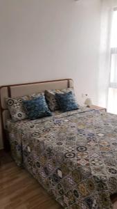 a bed with a comforter and pillows in a bedroom at Casa Strela Negra in Tarrafal +12 photos