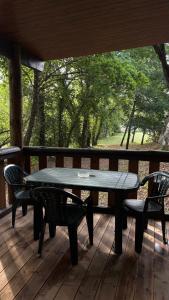 a table and two chairs on a wooden deck at Casinha das bonecas in Adenodeiro