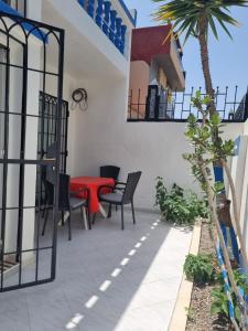 a patio with a red table and chairs at Appartement Imi-Ouaddar 2 in Agadir nʼ Aït Sa