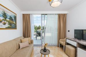 a living room with a couch and a television at ARABESQUE Apartments & Suite in Ulcinj