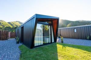 a black house with glass doors on the grass at La Cautiva in Lozano