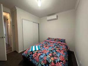 ein Schlafzimmer mit einem Bett mit einer farbenfrohen Bettdecke in der Unterkunft Your Guest House in Tarneit