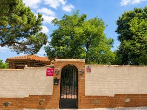 a brick wall with a black door and trees at El encinar de las nieves - Piscina privada, cerca de Toledo y Puy du Fou in Toledo +44 photos