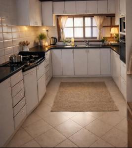 a kitchen with white cabinets and black counter tops at Sea view panorama 62 in Haifa