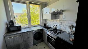 a kitchen with a stove and a washing machine at Spanko u Jadzi in Wałbrzych