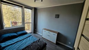 a bedroom with a bed and a large window at Spanko u Jadzi in Wałbrzych