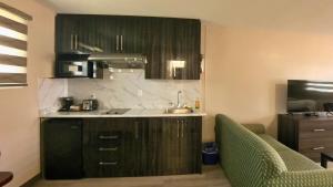 a kitchen with a sink and a counter with two chairs at Maple Leaf Inn & Suites in Kincardine