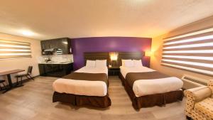 a hotel room with two beds and a kitchen at Maple Leaf Inn & Suites in Kincardine