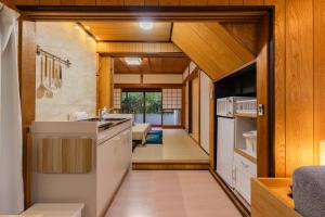 a kitchen with white appliances and wooden walls at 民泊YADOOR East House & West House in Iga