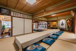 a large room with a large bed and blue chairs at 民泊YADOOR East House & West House in Iga