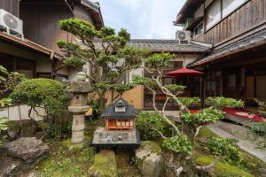 a garden with a small house and a building at 民泊YADOOR East House & West House in Iga