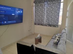 a living room with a couch and a flat screen tv at Casa independiente de 2 pisos con 03 cuartos in Morales