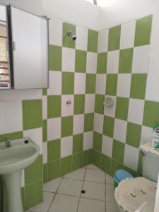 a bathroom with a green and white checkered wall at Casa independiente de 2 pisos con 03 cuartos in Morales +4 photos