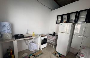 a kitchen with a white refrigerator and a stove at Casa por temporada - Espaço Oxente - Lazer e eventos in Paulo Afonso