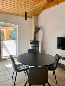 a dining room with a black table and chairs at Ferienhaus Kobel in Stromberg