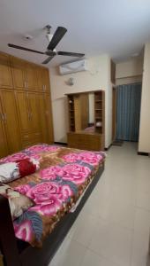 a bedroom with a bed with pink flowers on it at Stay with Comfort in Cox's Bazar