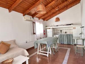 a living room with a table and a kitchen at Cabaña Cali in Cafayate
