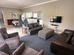 a living room with a couch and a tv at Steenkoppies semi self catering apartment in Magaliesburg