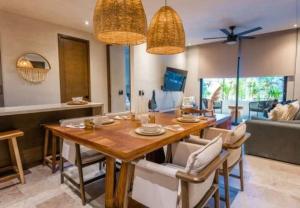 a dining room with a wooden table and chairs at Bakal Luxury Condos in Tulum