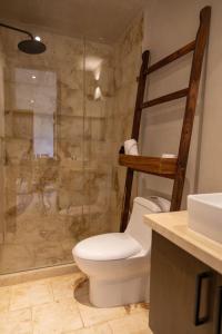 a bathroom with a shower with a toilet and a sink at Bakal Luxury Condos in Tulum
