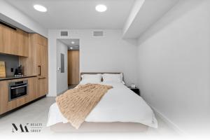 a white bedroom with a bed and a kitchen at Walking Distance from Bayside Market Place - 501 First Residences Junior Studio Rooftop Pool in Miami