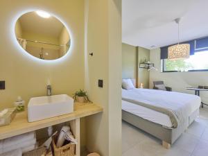 a bedroom with a bed and a sink and a mirror at Huus 16 in Zutendaal