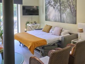 a bed with a blanket on it in a room at Huus 16 in Zutendaal