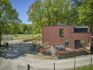 a brick house with a table in a yard at Huus 16 in Zutendaal